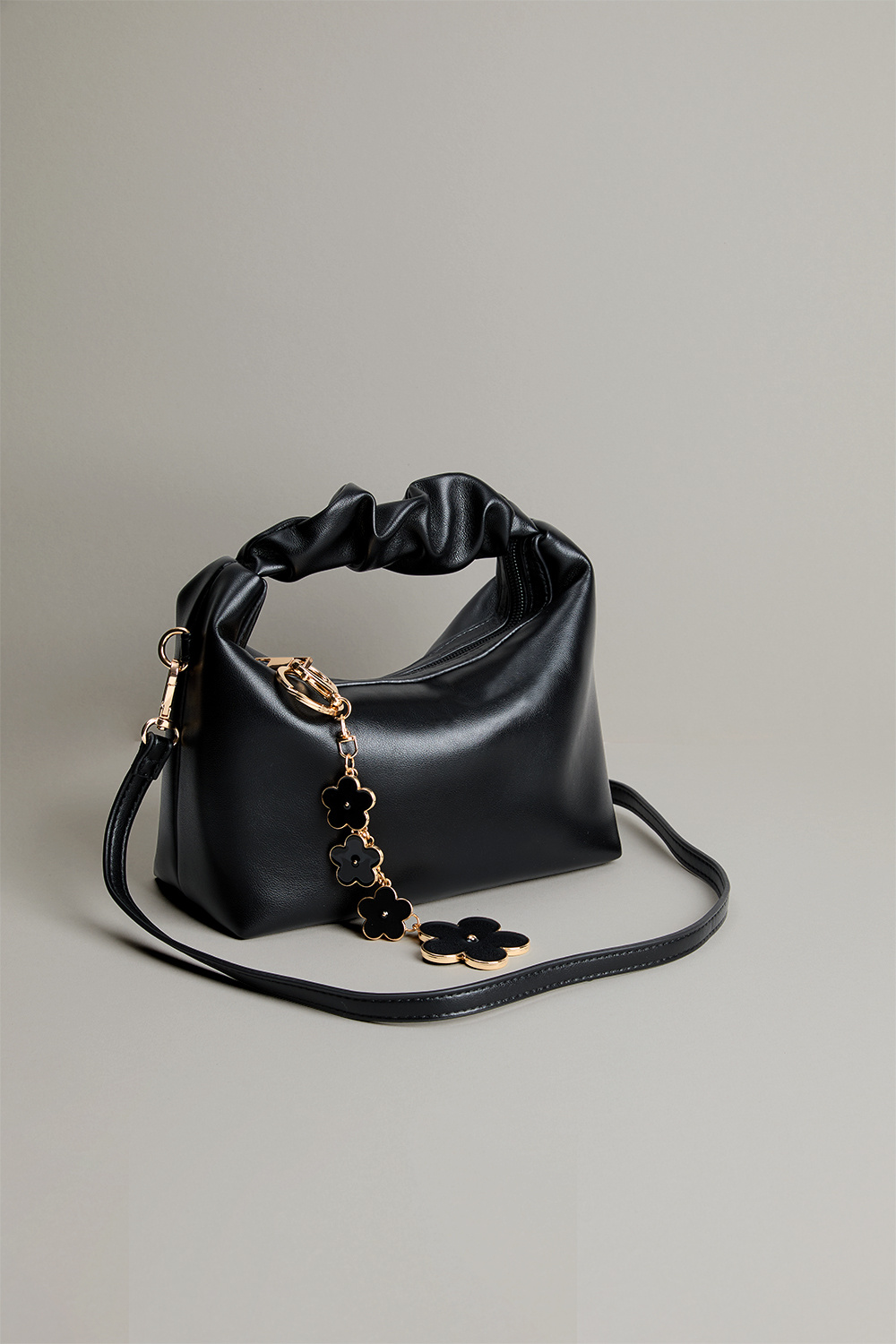 Liten, svart veske med rynket håndtak