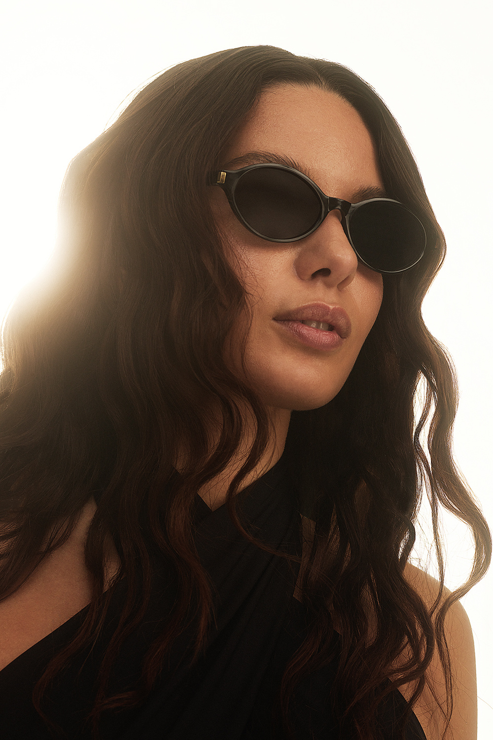 Svarte, ovale solbriller med gullfargede detaljer