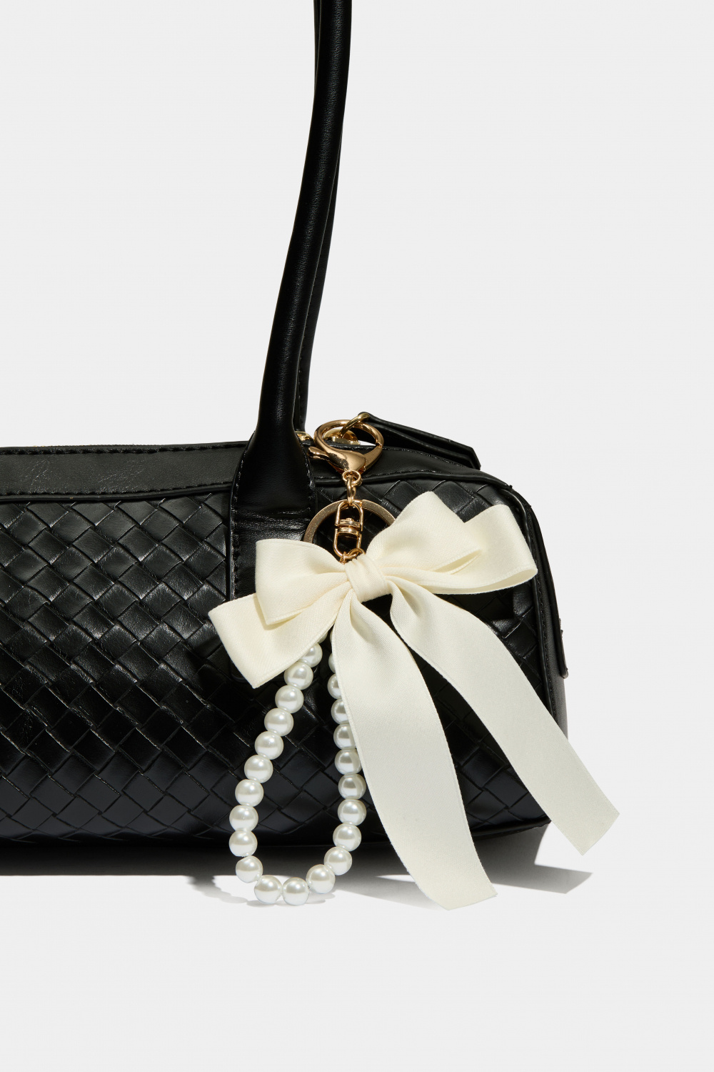 Veskedekor med hvit sløyfe og perlebånd