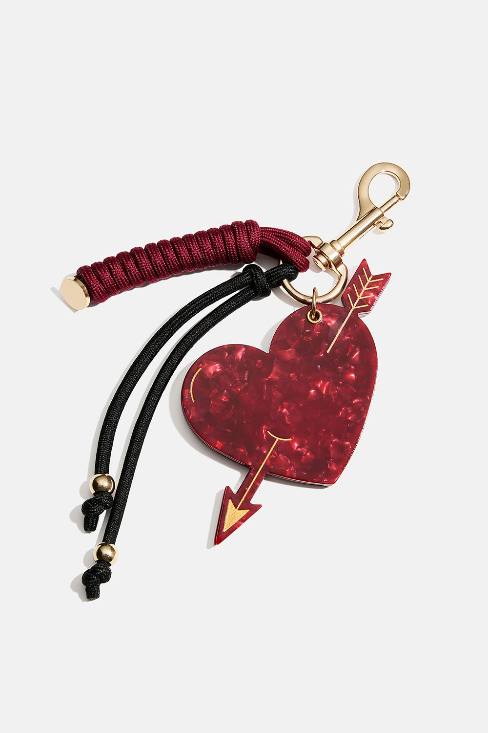 Veskedekorasjon med lite speil, hjerte og snorer.