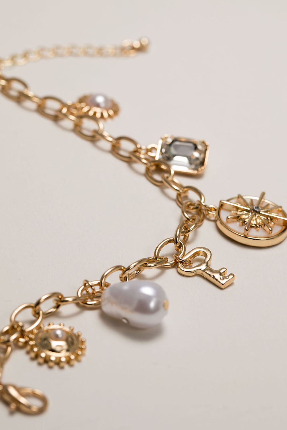 Gullfarget armbånd med sjarms