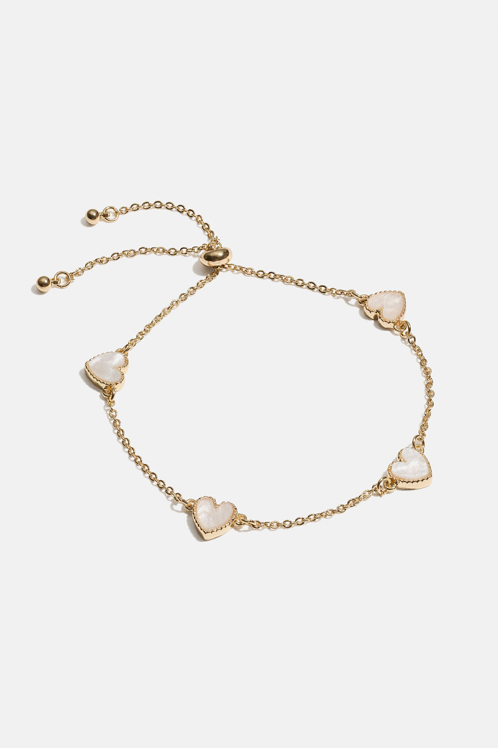 Gullfarget armbånd med hvite hjerter