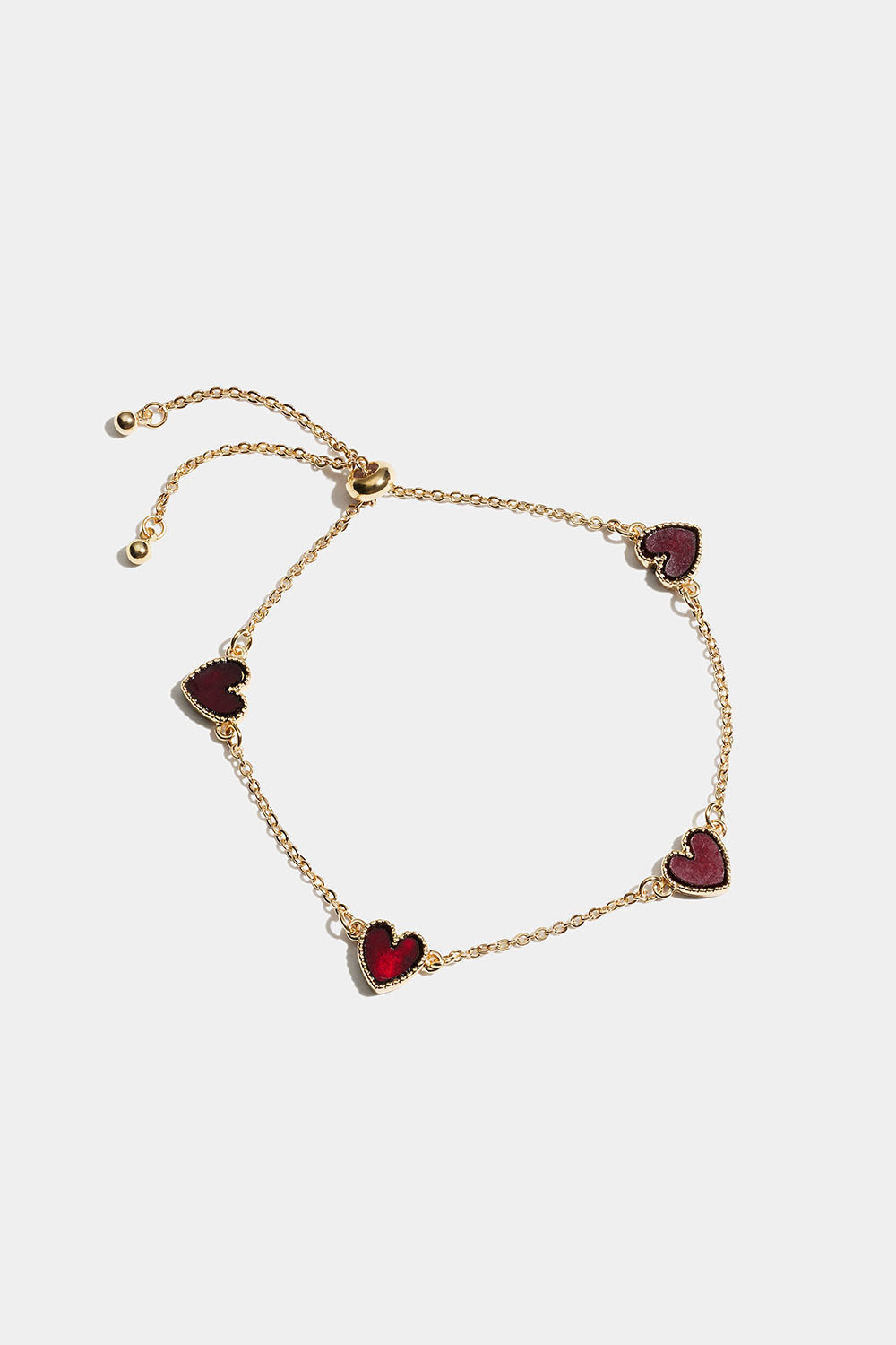 Gullfarget armbånd med røde hjerter