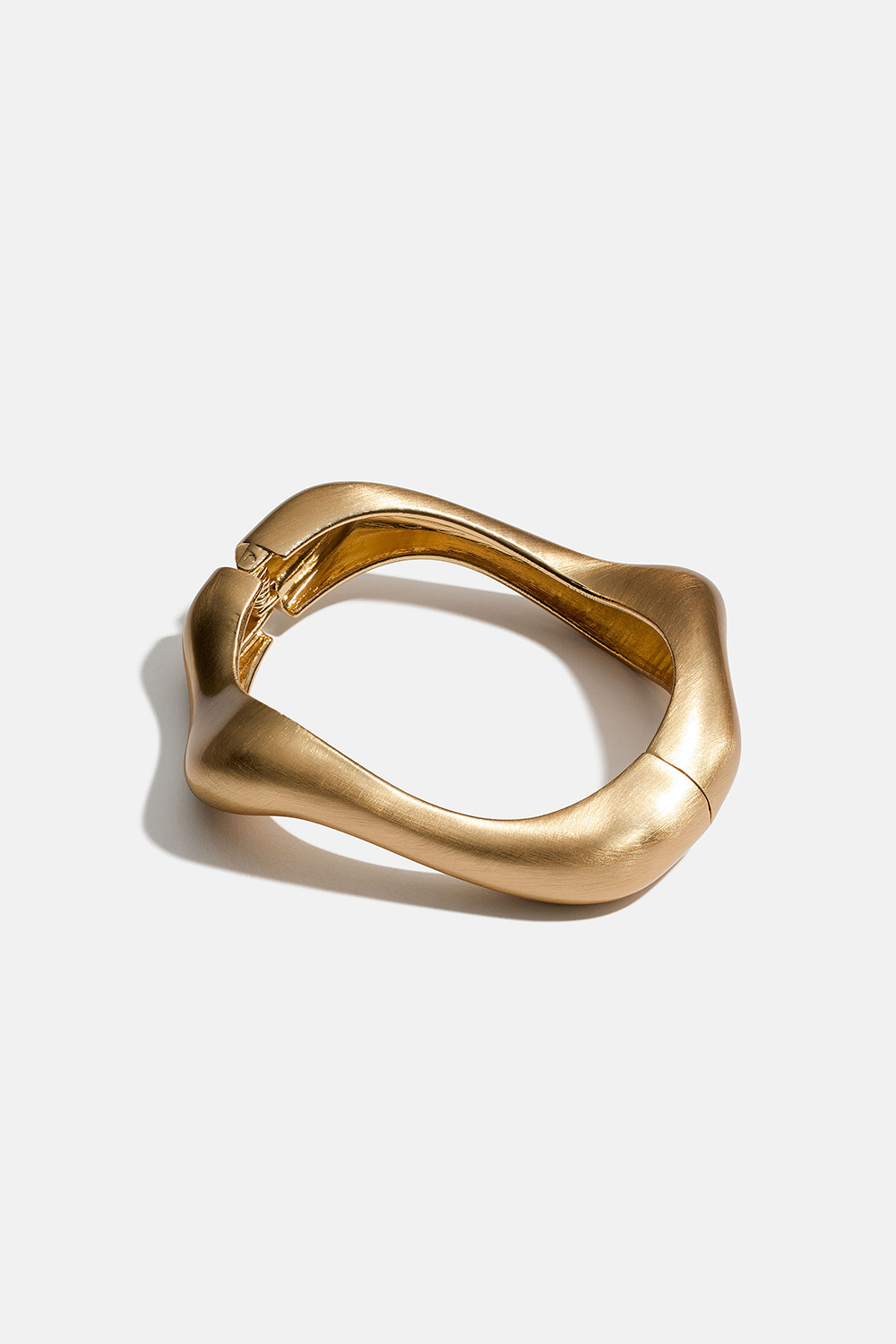 Gullfarget bangle-armbånd i bølgeform med børstet overflate