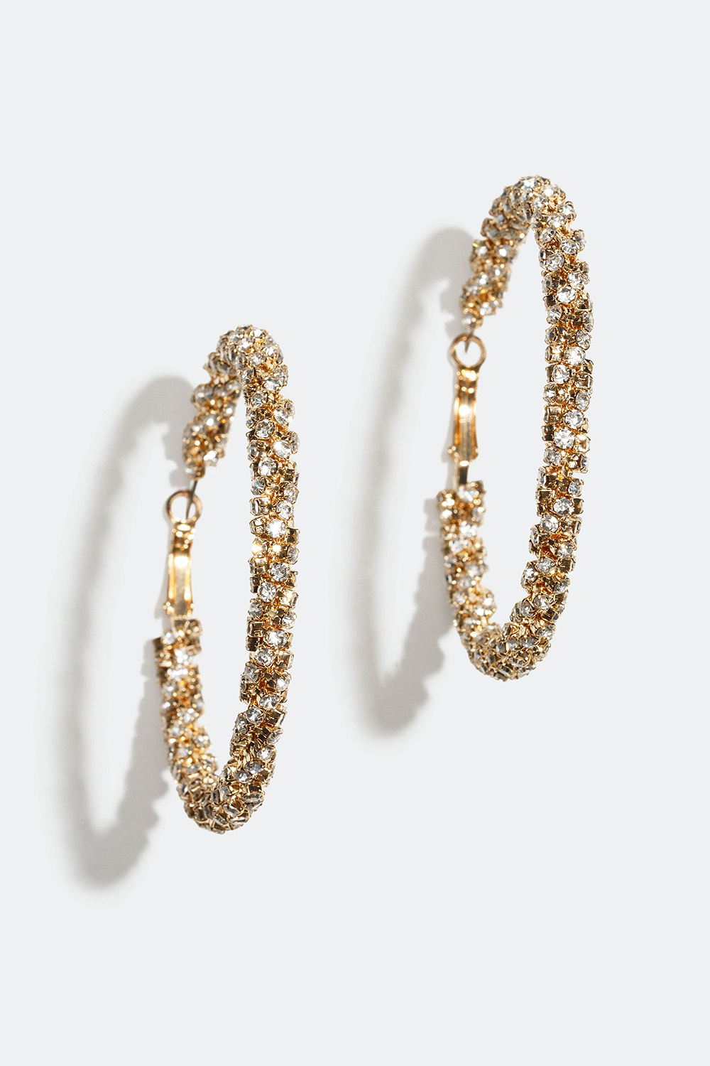 Store gullfargede øreringer med vridde glassteiner