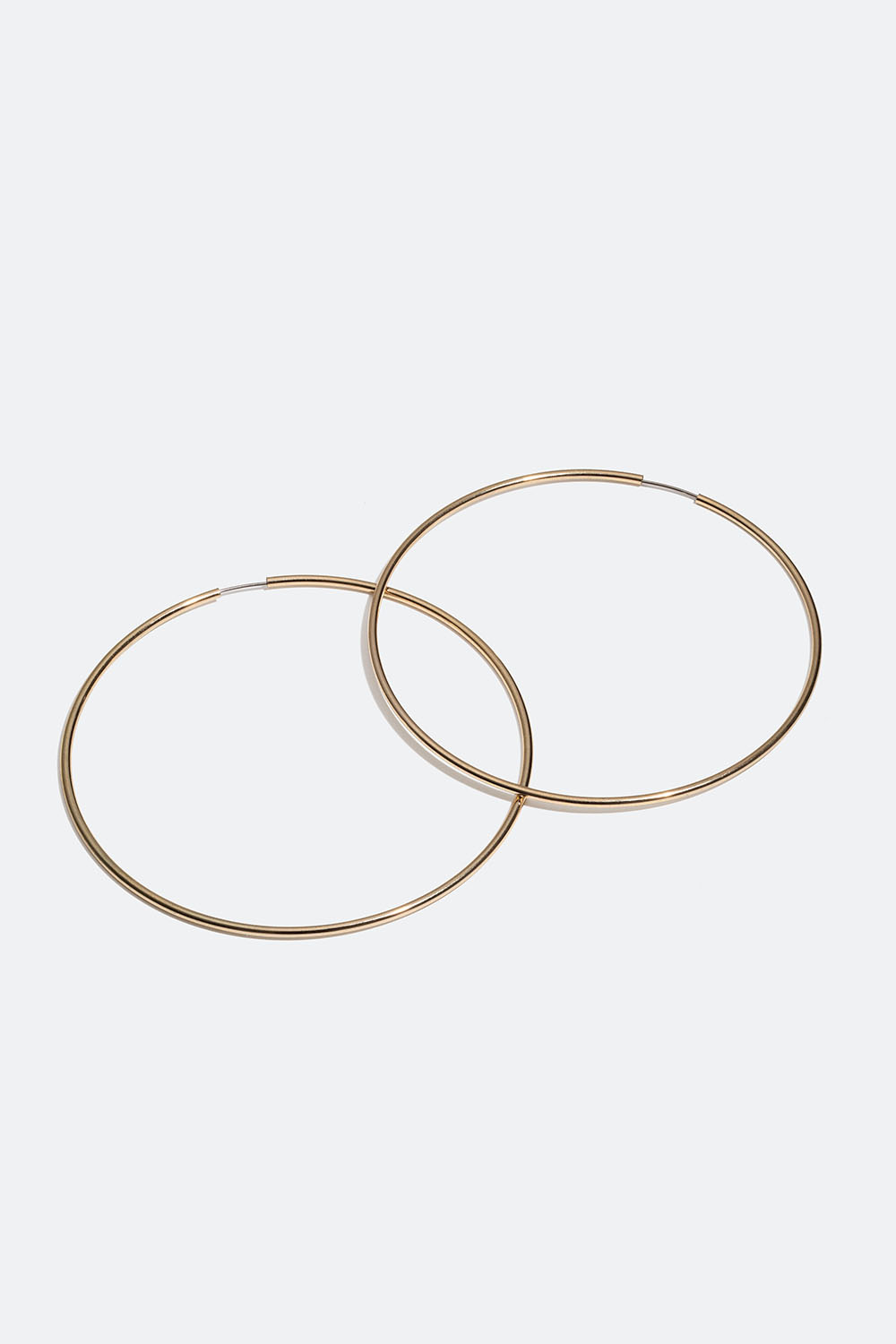 Store, smale øreringer i gullfarget metall.