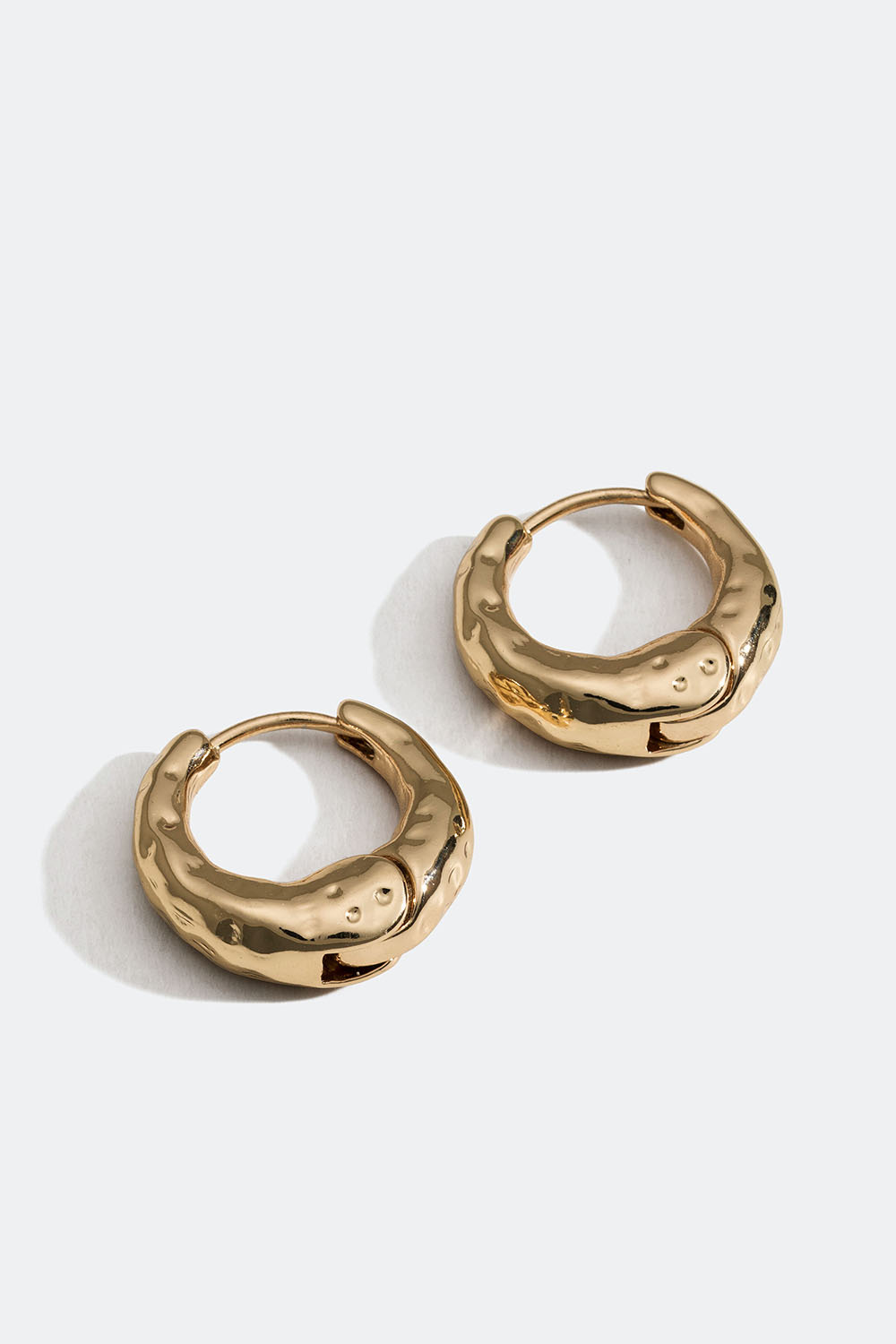 Små kraftige gullfargede øredobber med struktur