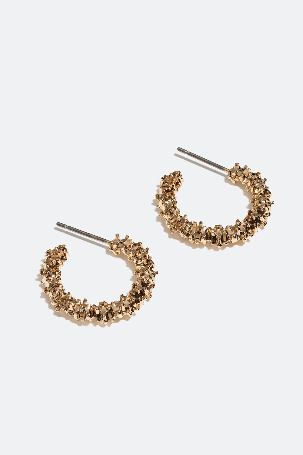 Små gullfargede øredobber med struktur