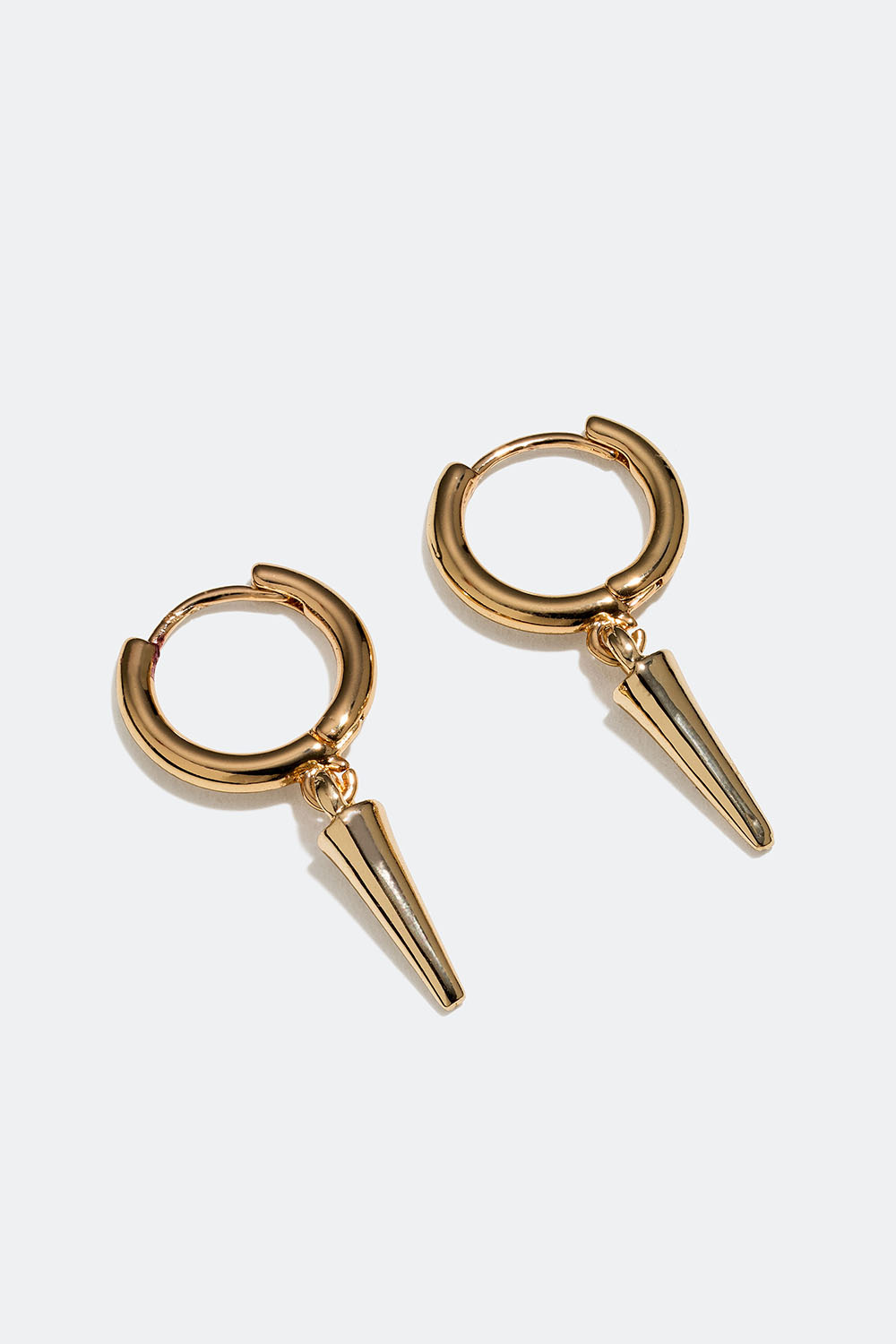 Små, gullfargede øreringer med nagler