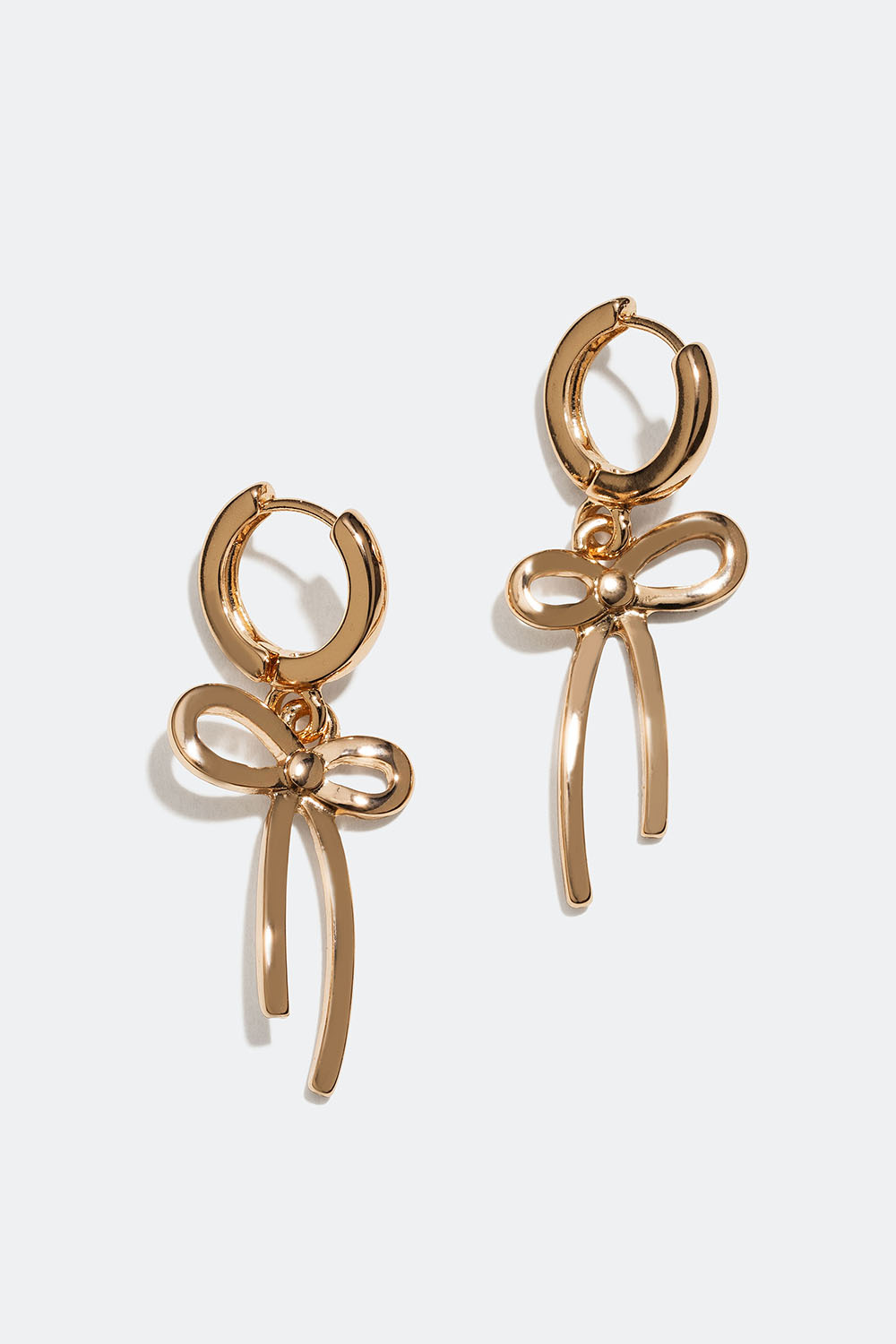 Små, gullfargede øreringer med sløyfer