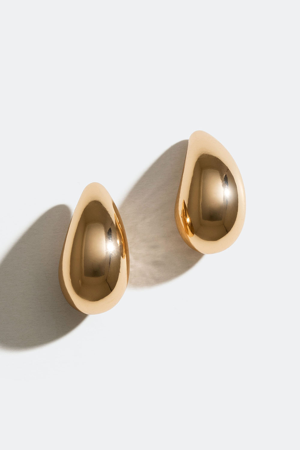 Små, gullfargede, dråpeformede øredobber