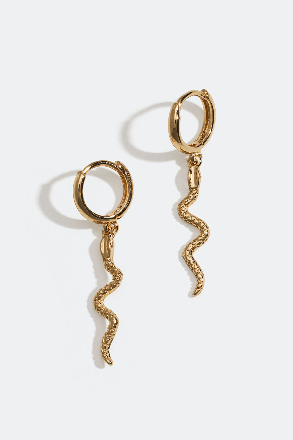 Små, gullfargede øredobber med slanger