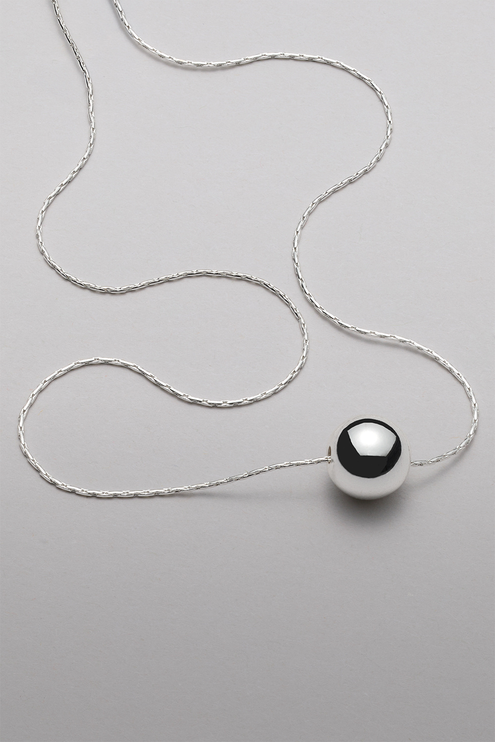 Rundt halskjede med sølvfarget perle