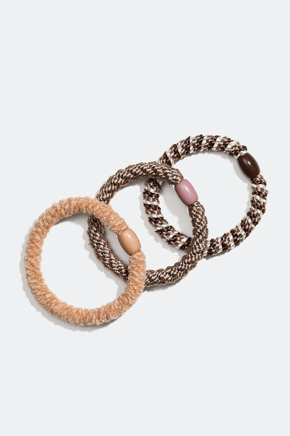 En blanding av flettede hårstrikker i beige og brunt, 3 pakning