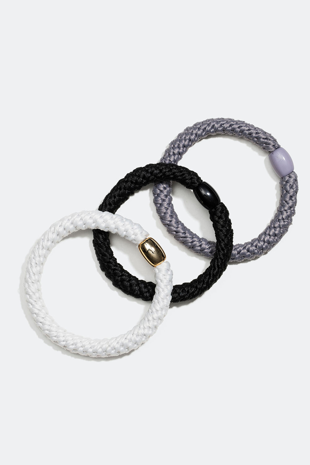 Flettede hårstrikker i en blanding av svart, grått og hvitt, 3-pakning