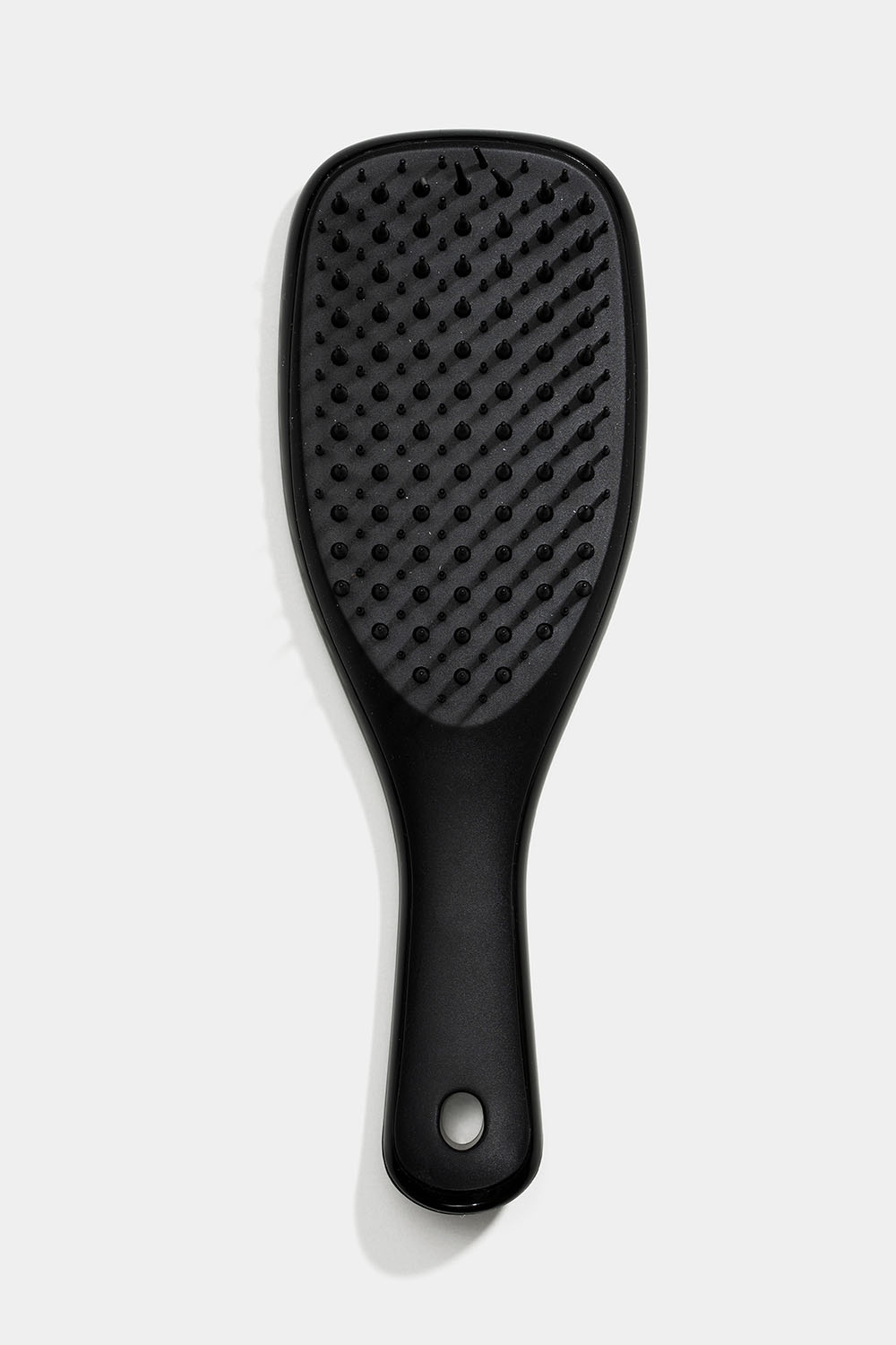 Liten, svart hårbørste mot floker